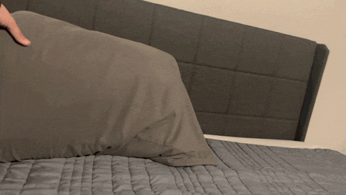 a person laying on a bed with a pillow on top of them