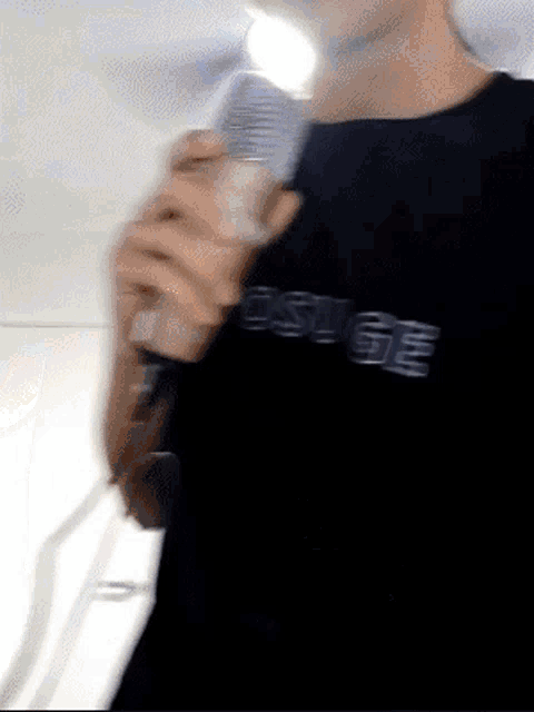 a person wearing a black shirt that says osuge