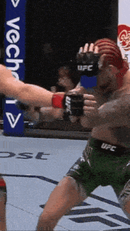 two men are fighting in a boxing ring .