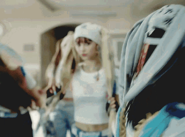 a blurry picture of a woman wearing a white hat and a crop top