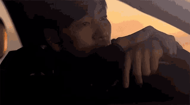 a close up of a person 's face with their hand on their face .