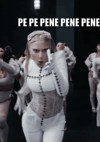 a woman in a white outfit stands in front of a group of dancers with the words pe pe pene pene pene written below her