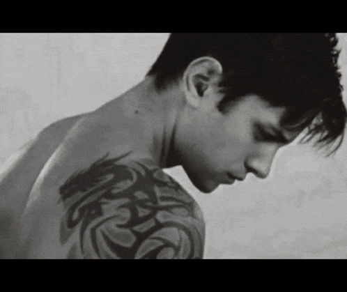 a man without a shirt has a tattoo on his arm