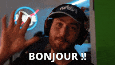 a man wearing headphones and a nasa hat is saying bonjour
