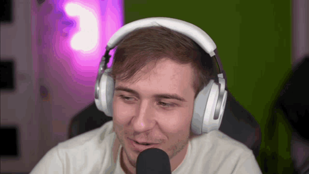 a man wearing headphones looks at the camera with the number 3 in the background