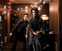 a man and a woman are standing next to each other in a room with christmas lights on the ceiling .
