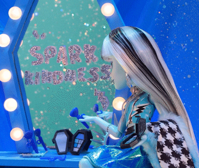 a doll sitting in front of a mirror with the words spark kindness on it