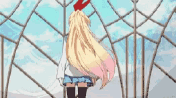 a blonde anime girl with long hair is standing in front of a fence .