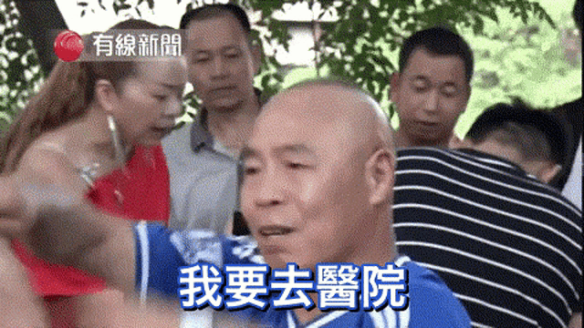 a group of people are gathered around a bald man with chinese writing on his face