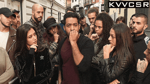 a group of people standing in front of a sign that says kvvcsr on it