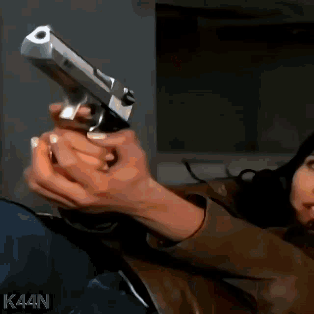 a woman is holding a gun with the letters k44n on the bottom right