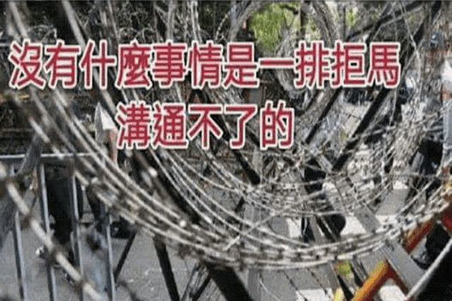 a barbed wire fence with chinese writing on the bottom
