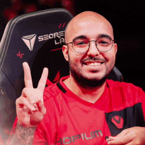 a man wearing glasses and a red shirt that says opium