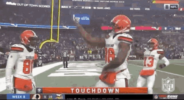 three cleveland browns players celebrate a touchdown during a football game