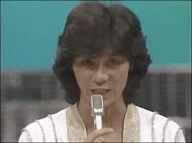 a woman is holding a microphone in front of her mouth