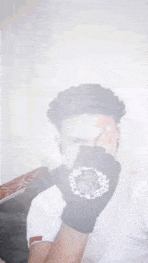 a man wearing a black glove with a crown on it is covering his face