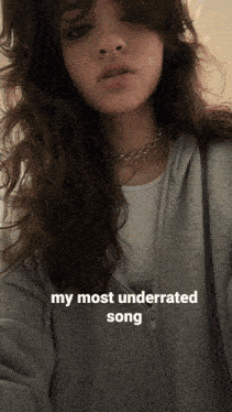 a woman is wearing a grey hoodie and a choker with the words " my most underrated song " written below her