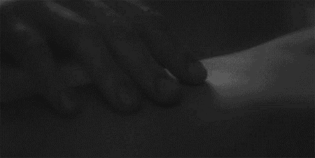 a black and white photo of a person 's hands on their face .