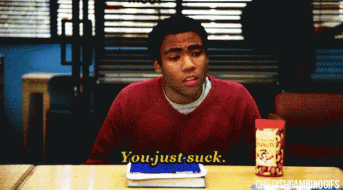 a man is sitting at a desk with a box of peanuts in front of him and says you just suck