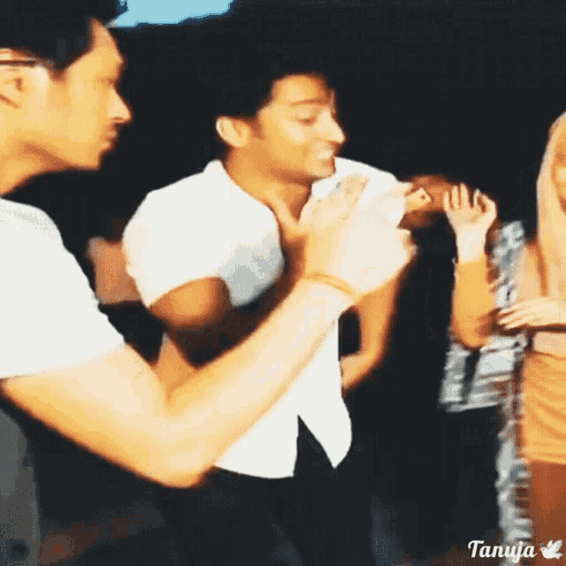 a group of people are dancing in a dark room with tanya written on the bottom of the image