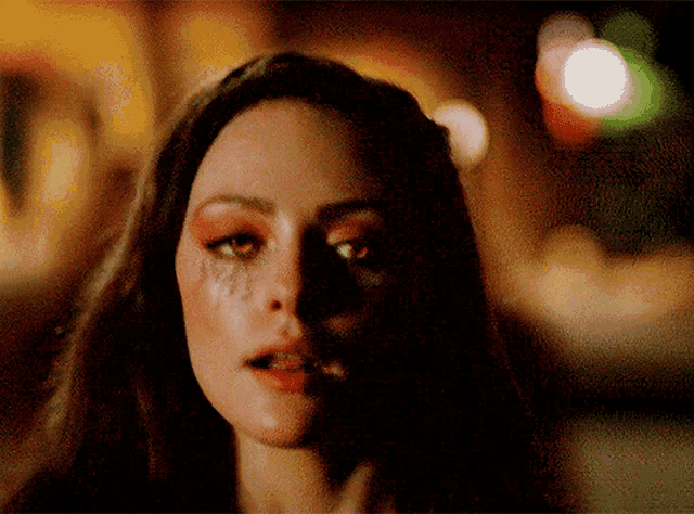 a close up of a woman 's face with a tear running down her cheek