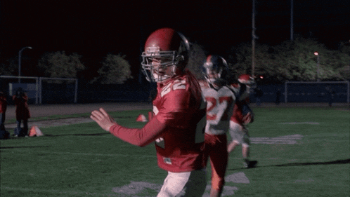 a football player wearing a red jersey with the number 27 on it