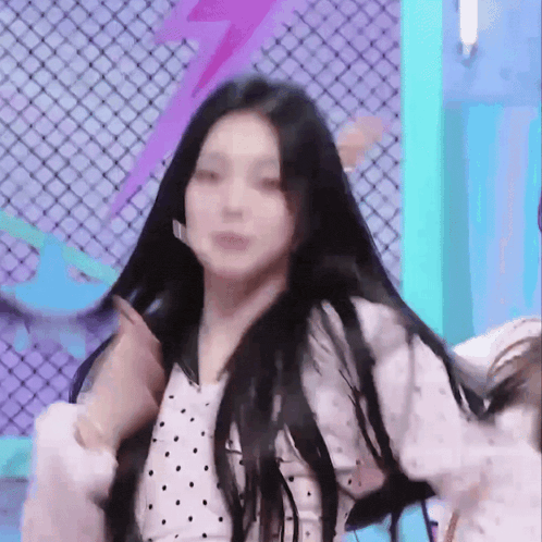 a girl with long black hair is dancing on a stage .