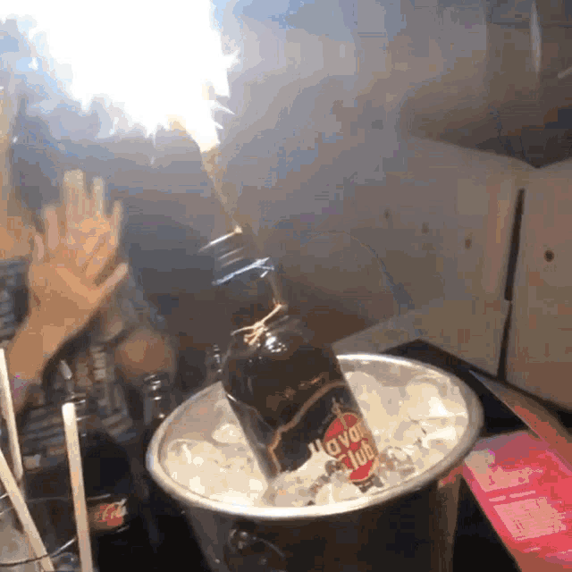 a bottle of havana club rum is being poured into a bucket of ice