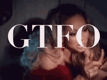 a woman is sitting in front of a sign that says `` gtfo '' .