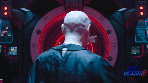 a bald man is standing in front of a sonic 3 advertisement