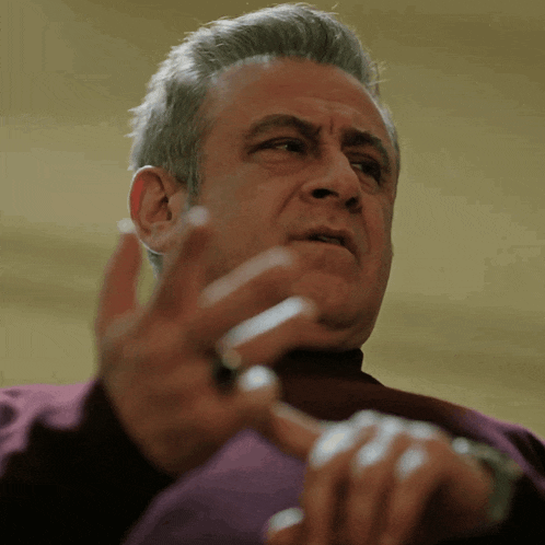 a man wearing a watch and a ring on his finger