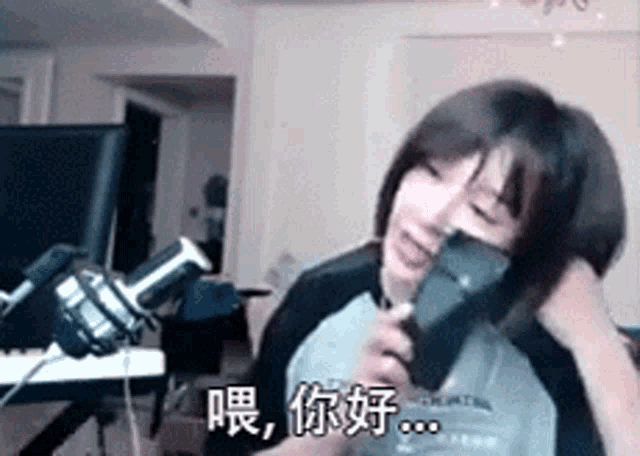 a woman is holding a cell phone in front of a microphone and talking into it .