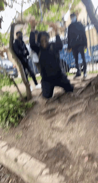 a blurry picture of a person kneeling down with their hands in the air