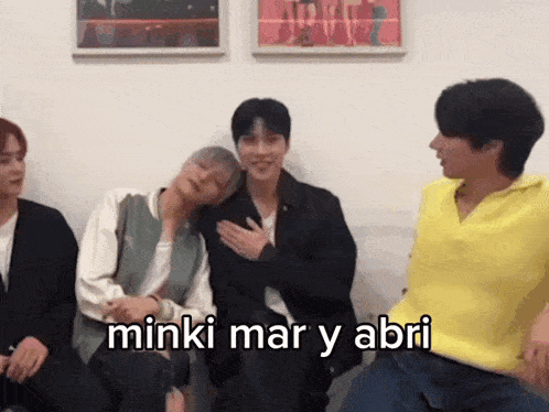 a group of young men are sitting next to each other with the words minki mar y abri written on the screen .