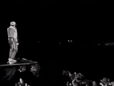 a man is standing on a stage holding a microphone and singing into it .