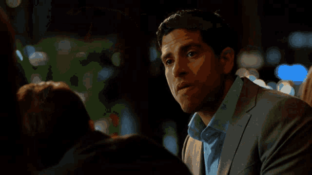 a woman is looking over her shoulder at a man