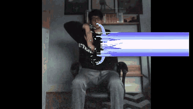 a man is sitting in a chair with a shirt that says estick