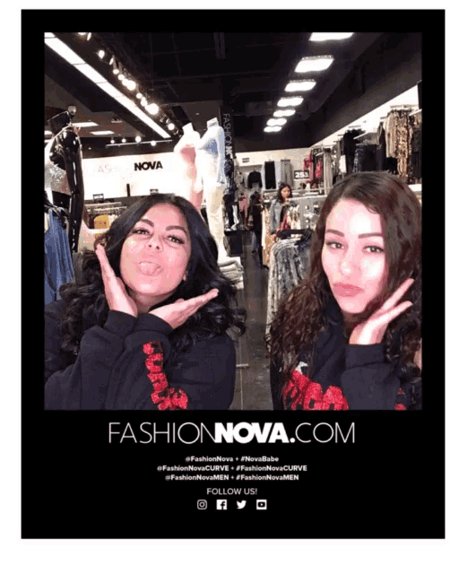 two women pose for a photo in front of a fashionnova.com sign