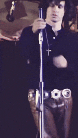 a man in a black shirt is holding a microphone in his right hand