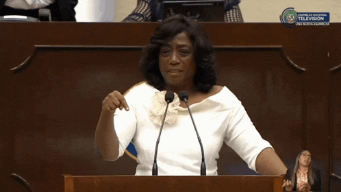 a woman giving a speech in front of a podium that says ' congress '