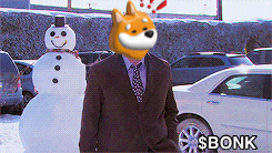 a man in a suit and tie is standing next to a snowman with a dog 's head on it
