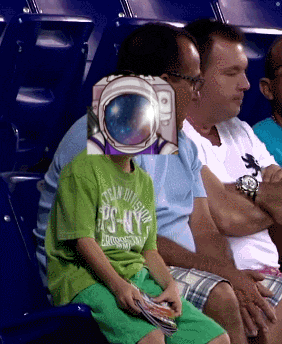 a boy wearing a green shirt that says ps-ny sits in the stands