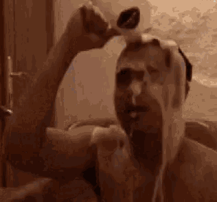 a man is taking a bath in a bathtub with foam on his head .