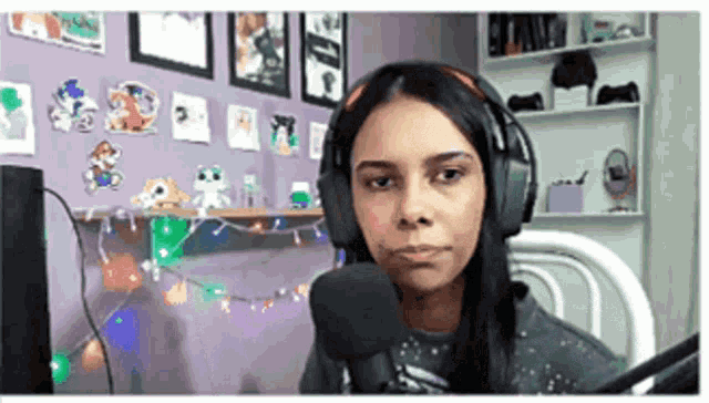 a woman wearing headphones and a microphone is sitting in front of a computer