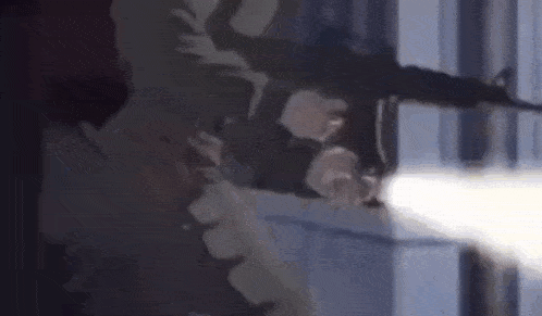 a man is holding a gun in his hand and pointing it at someone .