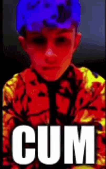 a young boy is wearing a blue hat and a red and yellow jacket with the word cum written on it .