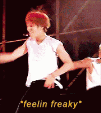 a man with red hair is dancing on a stage with the words " feelin freaky " behind him