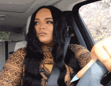 a woman is sitting in a car wearing a shirt that says ' i love you ' on it