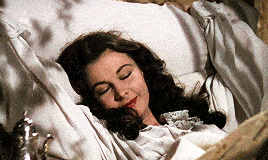 a woman laying in bed with her eyes closed
