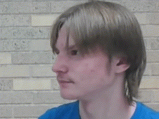 a close up of a man 's face with a blue shirt on